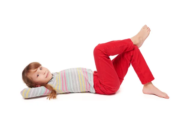 Vista lateral de niña sonriente acostada en el suelo — Foto de Stock