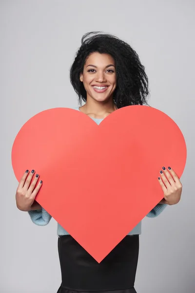 Chica sosteniendo gran forma de corazón rojo —  Fotos de Stock