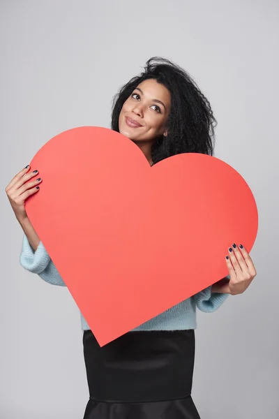 Chica sosteniendo gran forma de corazón rojo — Foto de Stock