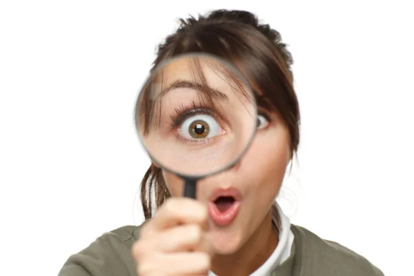 Surprised female looking at the camera through a magnifying glass — Stock fotografie