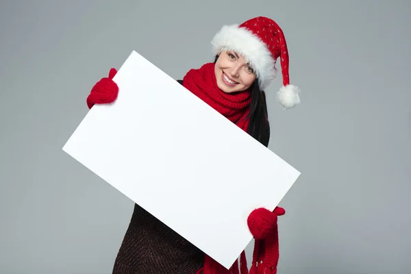 Woman in Santa hat holding white banner — Stok fotoğraf