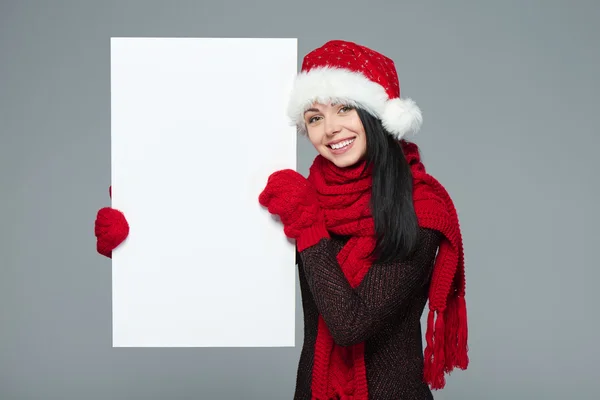 Woman in Santa hat holding white banner — Stok fotoğraf