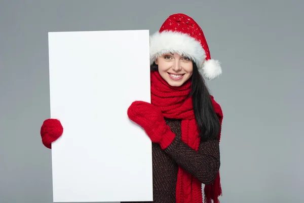 Woman in Santa hat holding white banner — Zdjęcie stockowe