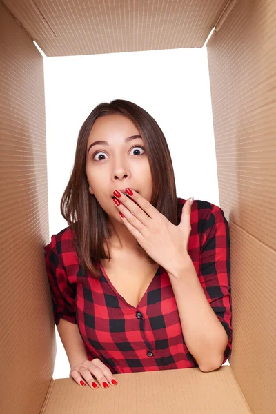 Girl opening a carton box and looking inside — Stock Photo, Image