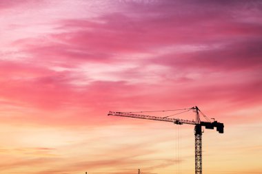 Günbatımı üzerinde highrise Vinçler