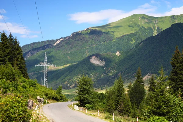 Dağ manzarası ile asfalt yol ve güç hattı — Stok fotoğraf