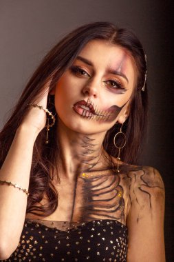 Cadılar Bayramı kafatası güzellik stüdyosunun karanlık arka planını oluşturur.