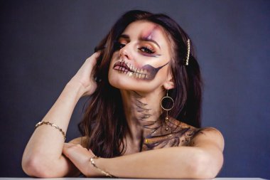 Cadılar Bayramı kafatası güzellik stüdyosunun karanlık arka planını oluşturur.