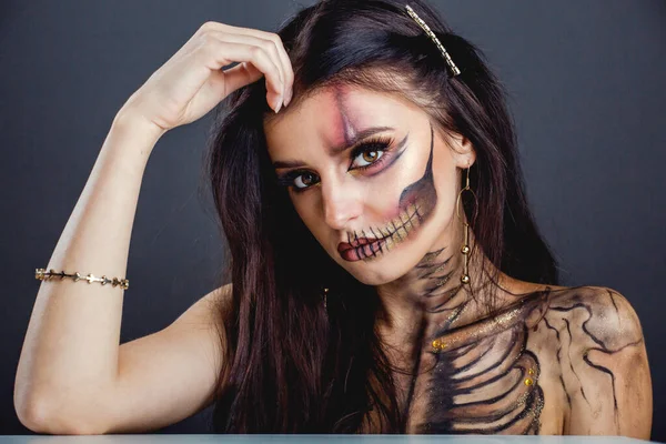 Cadılar Bayramı kafatası güzellik stüdyosunun karanlık arka planını oluşturur.