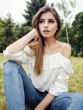 Dışarıdaki yeşil parkta bir kadın portresi.