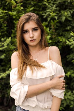 Dışarıdaki yeşil parkta bir kadın portresi.