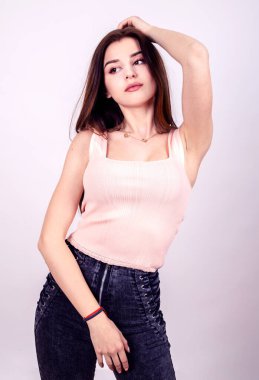 Modern elbiseli kadın stüdyo beyaz arka planda çekim yapıyor.