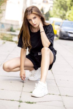 Sokakta poz veren modern siyah bir kadın.