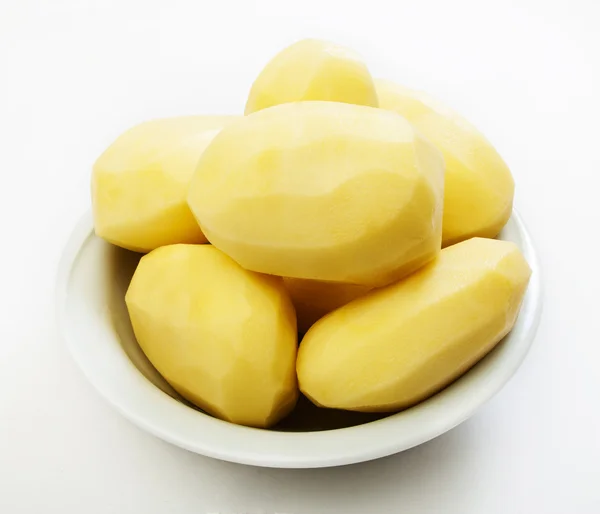 Beyaz bir arka plan üzerinde izole ham soyulmuş patates