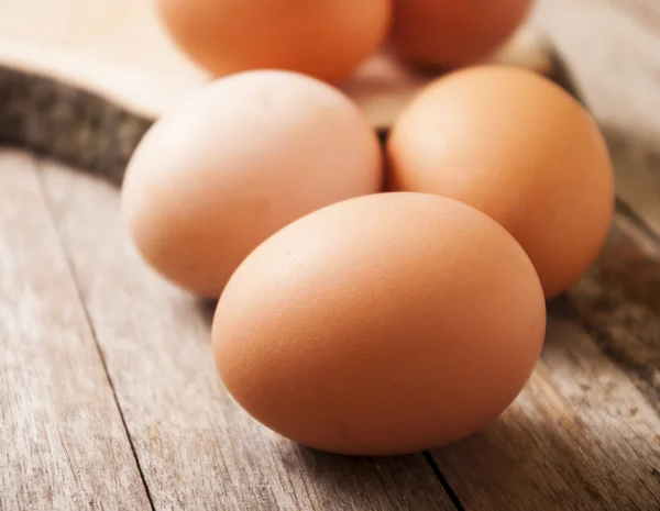 Свежие яйца закрываются на деревянном фоне — стоковое фото