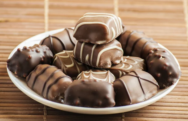 Pralines de chocolate na velha mesa de madeira — Fotografia de Stock