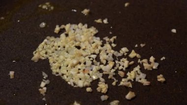 Sıcak yağın içinde tavada cızırdayan sarımsağı kapat.