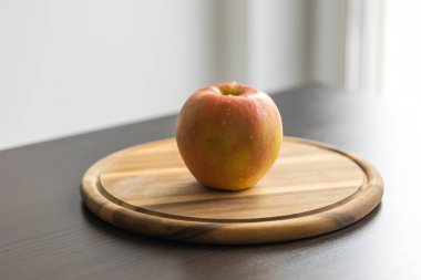 Tahta kesme tahtasının üzerinde taze çıtır elma var.