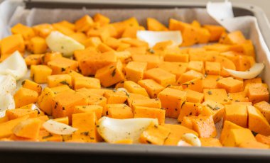 Doğranmış tereyağlı balkabağı soğan ve sarımsak, haşlanmaya hazır bitki ve baharatlar.