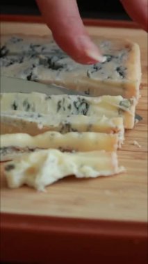 Ahşap tahtada kremalı mavi peynir dilimliyorum. Yaklaş.