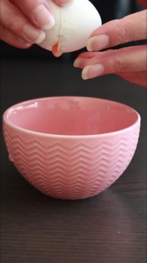 Kırık yumurta küçük pembe kasede. Taze malzemeyi kapat.