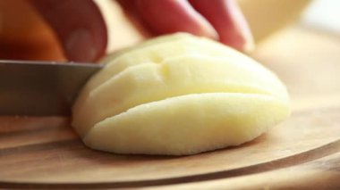 Tahta kesme tahtasında taze elma dilimliyorum. Yakın çekim.