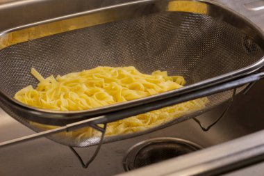 Eritilmiş taze makarna kevgire yakın.