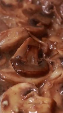 Tavada kremalı sosta pişen mantarların dikey yakın çekimi