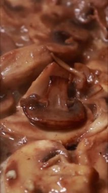 Tavada kremalı sosta pişen mantarların dikey yakın çekimi