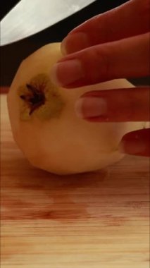 Kadın elleri tahta kesme tahtasıyla taze armut dilimliyor.