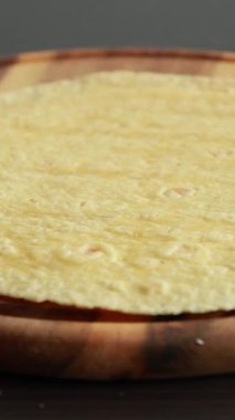 Tahta mutfak tezgahında mısır tortilla ekmeği katlıyorum.