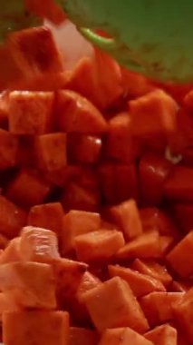 Tabaktaki baharatlarla karıştırılmış çiğ patates küpleri.