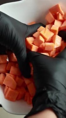 Tabaktaki baharatlarla karıştırılmış çiğ patates küpleri.