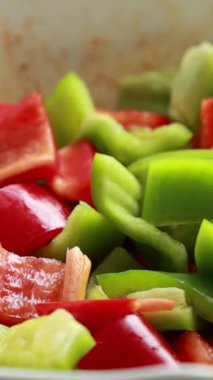 Taze dilimlenmiş kırmızı ve yeşil dolma biberler kapanıyor.