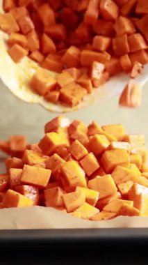 Pişirmek için tepside tatlandırılmış çiğ patates küpleri.