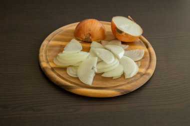 Tahta kesme tahtasında soğan doğruyorum. Yakın çekim.