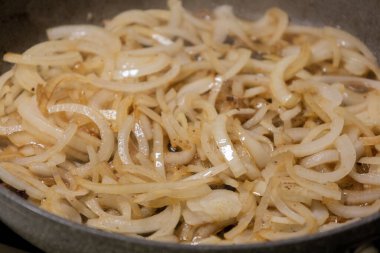 Soğan dilimleri sıcak tavada karamelize ediliyor.