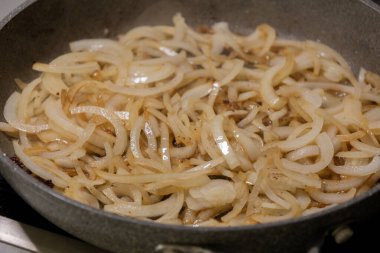 Soğan dilimleri sıcak tavada karamelize ediliyor.