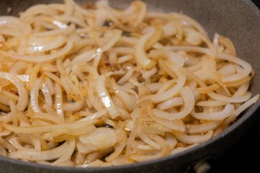 Soğan dilimleri sıcak tavada karamelize ediliyor.