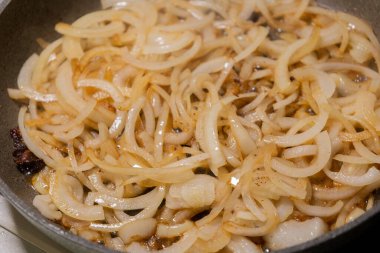 Soğan dilimleri sıcak tavada karamelize ediliyor.