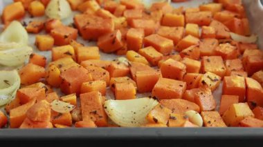 Tepside pişmiş kabak küpleri ve soğanlar yakın çekim