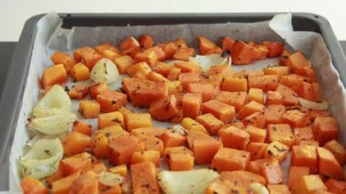 Tepside pişmiş kabak küpleri ve soğanlar yakın çekim
