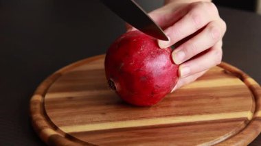 Taze nar dilimleyen ellerin yakın çekimi.