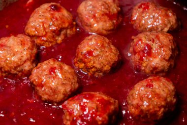 close-up of turkey meatballs simmering in cranberry sauce for thanksgiving