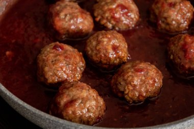 cooked turkey meatballs in pan with cranberry sauce