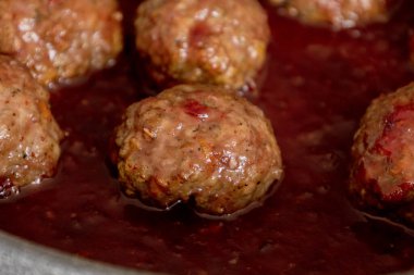 cooked turkey meatballs in pan with cranberry sauce