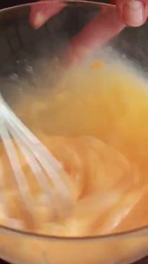 Kadın cam kaseye yumurta kırıyor. Yakından.