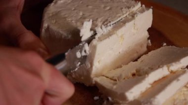 Tahta kesme tahtasında beyaz peynir dilimlemek