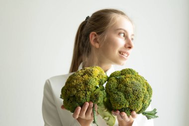 Brokoliyi arka planda tutan kız sağlıklı beslenme konsepti