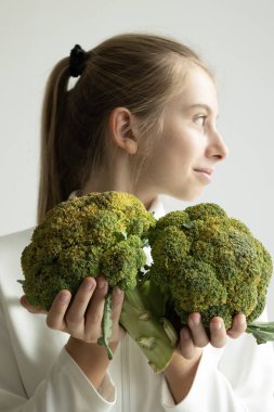 Brokoliyi arka planda tutan kız sağlıklı beslenme konsepti
